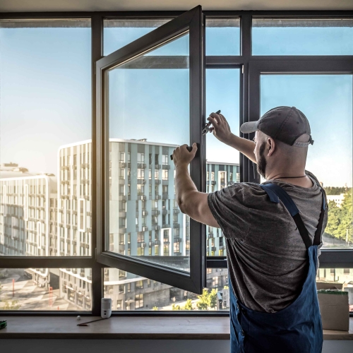 Tømrer i gang med udskiftning af vindue i moderne lejlighed – professionelt tømrerarbejde